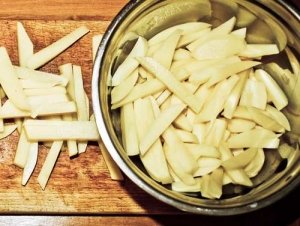 Kartoffeln beim Pommes selber machen in Streifen schneiden